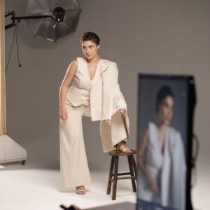 Modelka w jasnym kostiumie pozująca w studiu fotograficznym — zdjęcie ilustracyjne